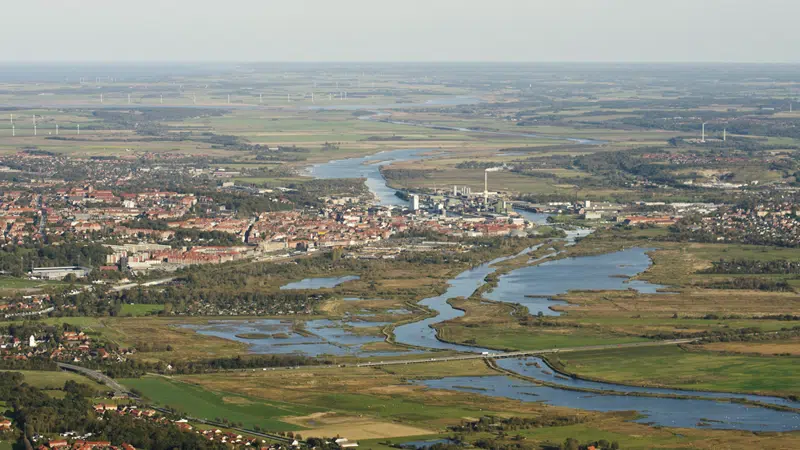 Luftfoto, der viser de genskabte våde enge i den brede ådal ved Randers